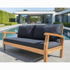 Wooden outdoor sofa with black cushions in a modern garden setting.
