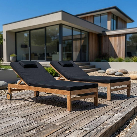 Two wooden outdoor sun loungers with wheels and black cushions on wooden decking