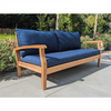 garden daybed with blue cushions on a gray patio