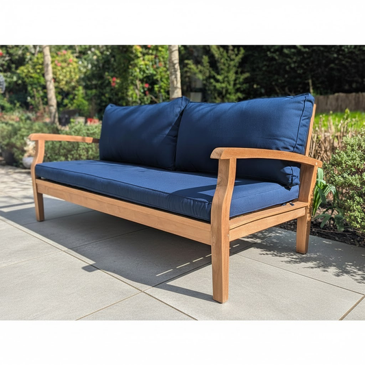 garden daybed with blue cushions on a grey patio