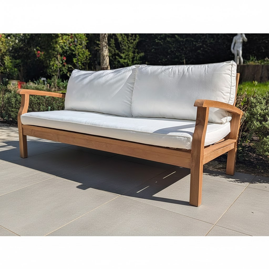 Wooden outdoor sofa with white cushions on a grey patio