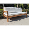 Wooden outdoor sofa with white cushions on a grey patio