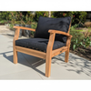 Wooden outdoor sofa with black cushions on a patio