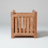Wooden teak planter box with decorative top on a white background