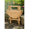 Wooden round outdoor coffee table with a handle in a garden setting