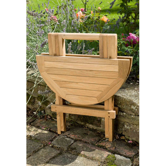 Wooden round outdoor coffee table with a handle in a garden setting
