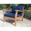 Wooden outdoor chair with blue cushions on a stone patio