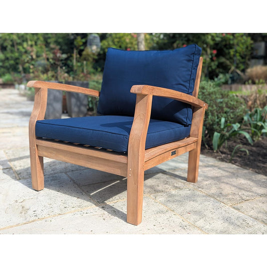 Wooden outdoor chair with blue cushions on a stone patio