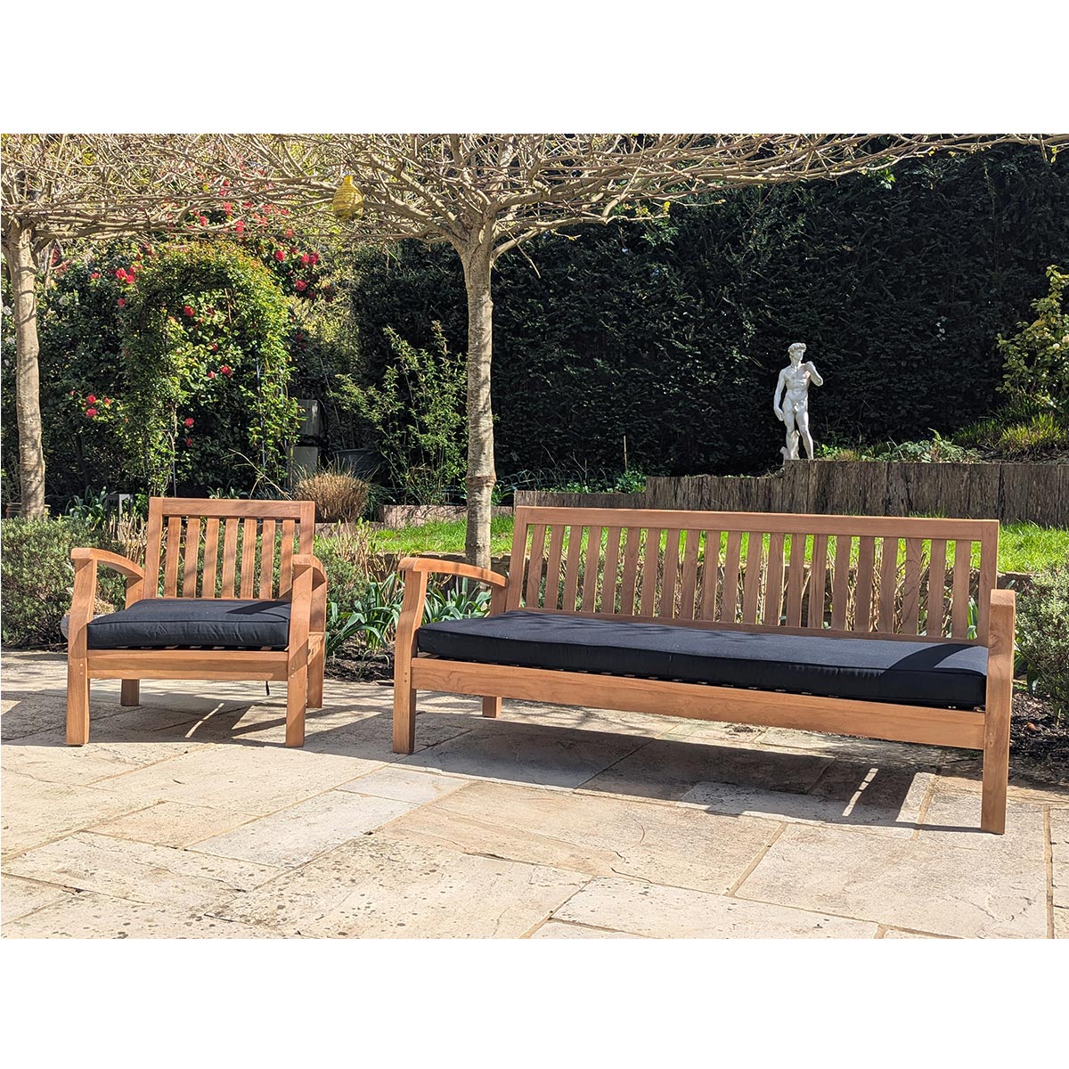 Wooden outdoor furniture set in black cushions with bench and chair on a patio