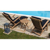 Two wooden lounge chairs with black cushions and a round folding coffee table by a poolside.