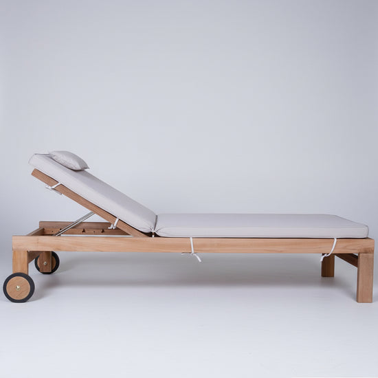 Wooden reclining sun lounger with white cushion on a white background