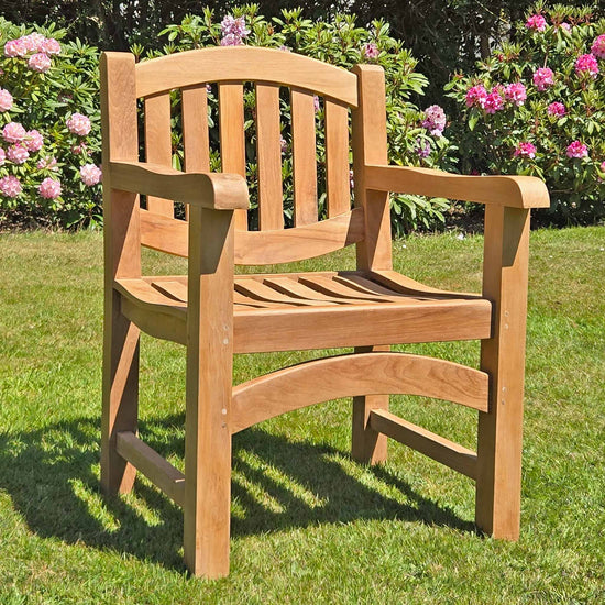 wooden oval teak garden armchair, Marden range, in a garden setting on a lawn