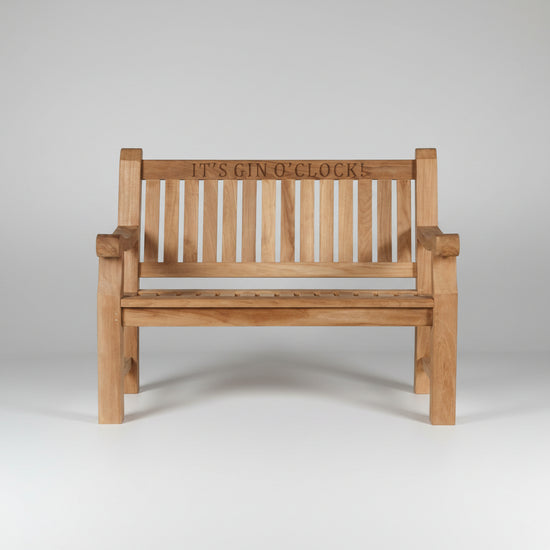 Wooden garden bench with 'IT'S GIN O' CLOCK' engraving on a white background