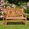 Wooden oval 2 seat garden bench, Marden, in a garden setting with pink flowers and greenery
