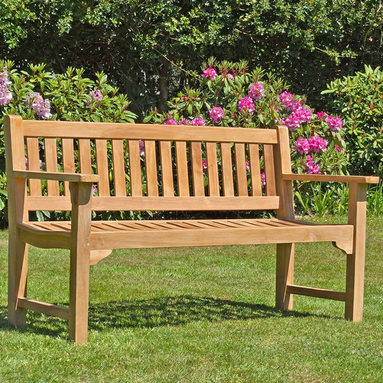 Wooden 3 seat teak garden bench, Farleigh, in a garden setting on a lawn