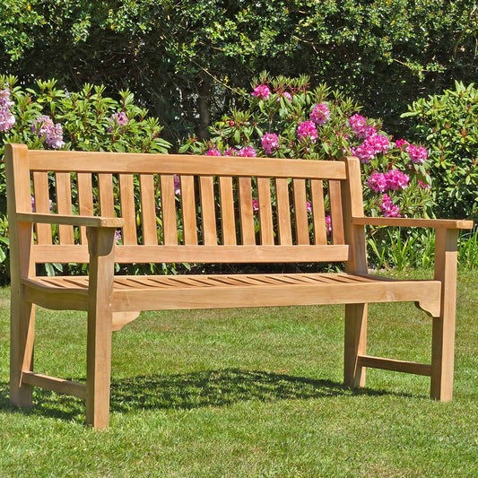 Wooden 3 seat teak garden bench, Farleigh, in a garden setting on a lawn