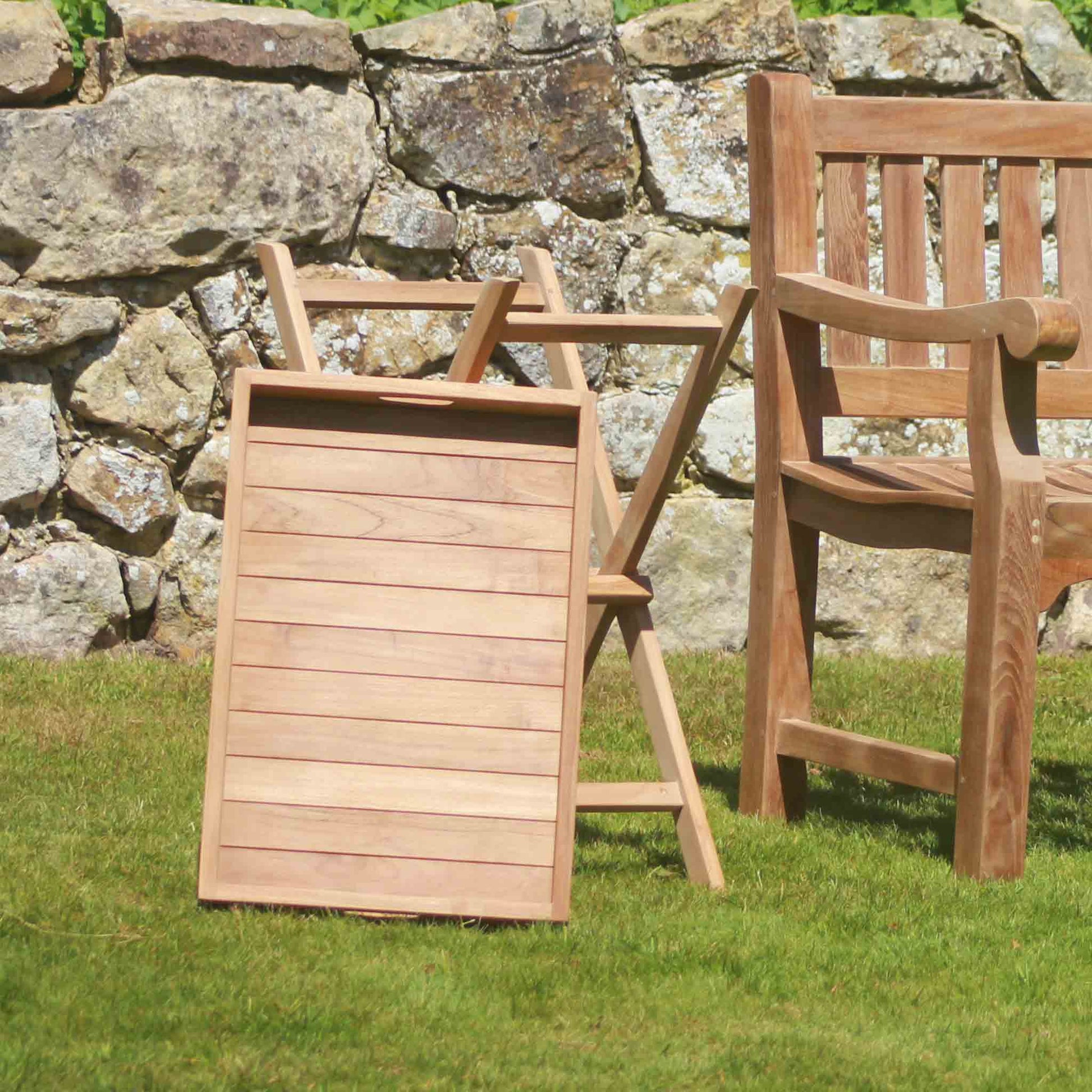 Wooden outdoor Serving Platter and Garden Side Stand against a stone wall