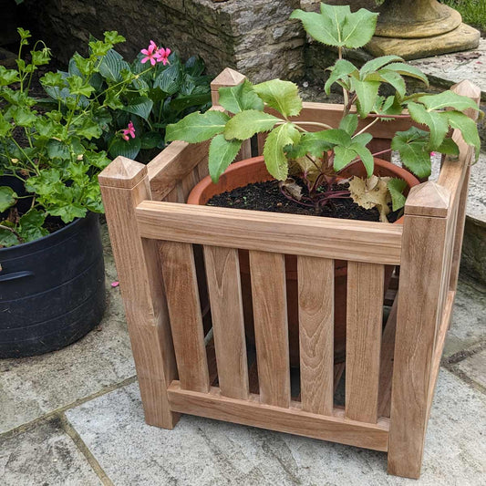 wooden teak garden planter box with plant on a patio setting