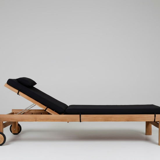 Teak wood sun lounger, with wheels,  black cushions white background