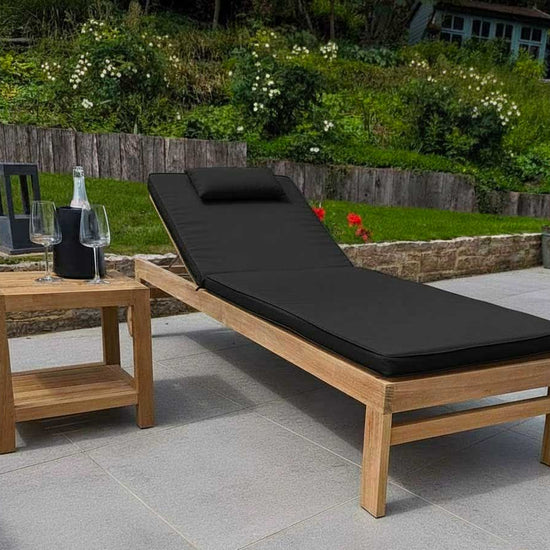 teak garden sun longer with wheels and a black cushion on grey ceramic tiles