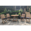 Wooden round folding teak outdoor table with four matching chairs on a paved area