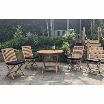 Wooden round folding teak outdoor table with four matching chairs on a paved area